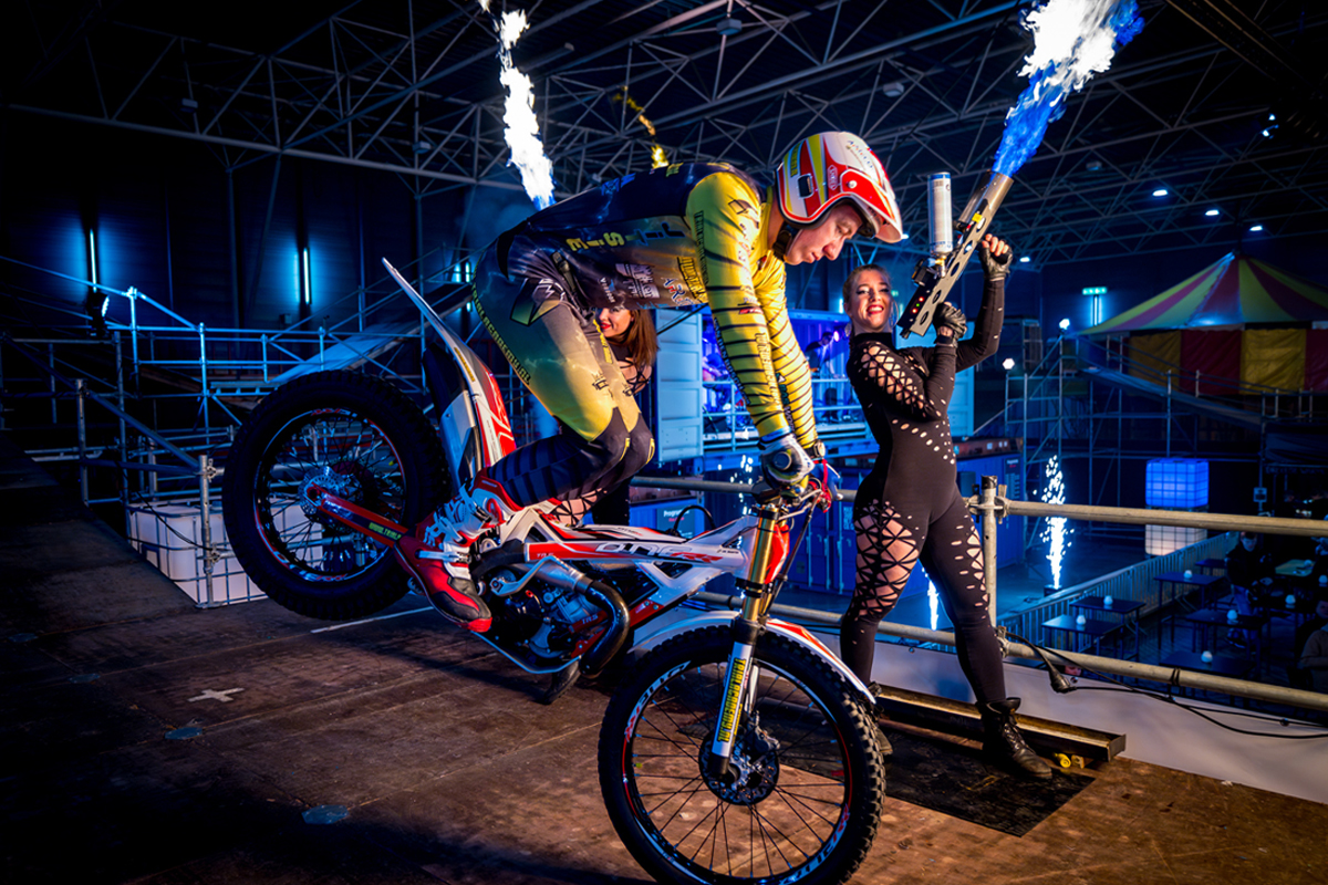 Stuntrijder op voorwiel met vuuracts in Fire Arena