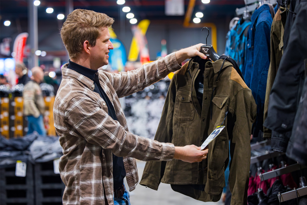 Man bekijkt motorjasje in motorkleding stand