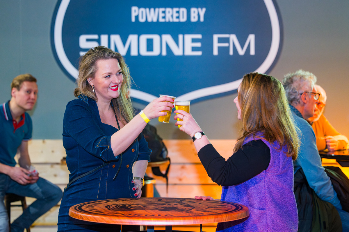 Twee dames proosten met een biertje in Route 66 Café