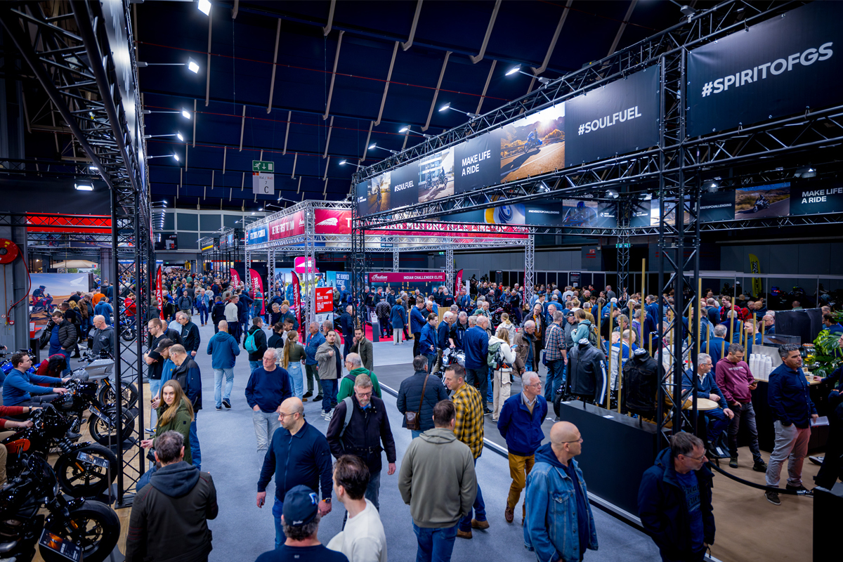 Bezoekers lopen langs stands en proberen motorfietsen uit