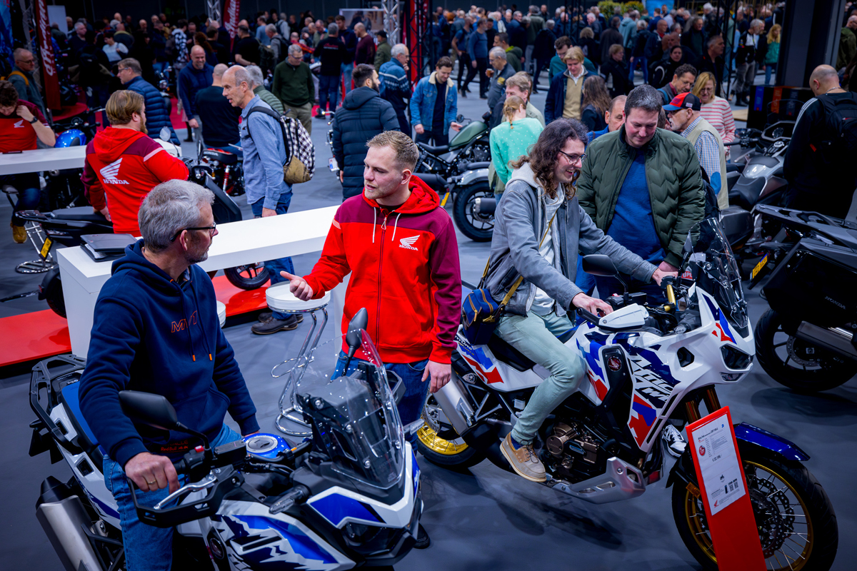 Bezoekers proberen motoren uit in Honda stand