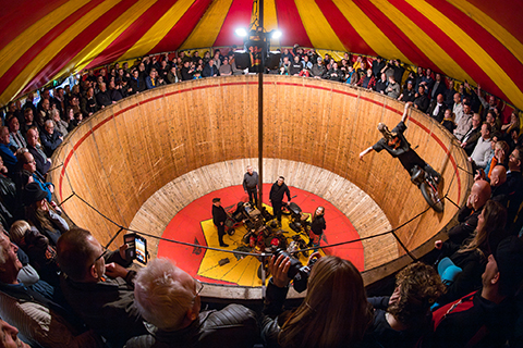 Motorrijder zonder handen aan het stuur rijdt in de Steile wand met publiek er omheen