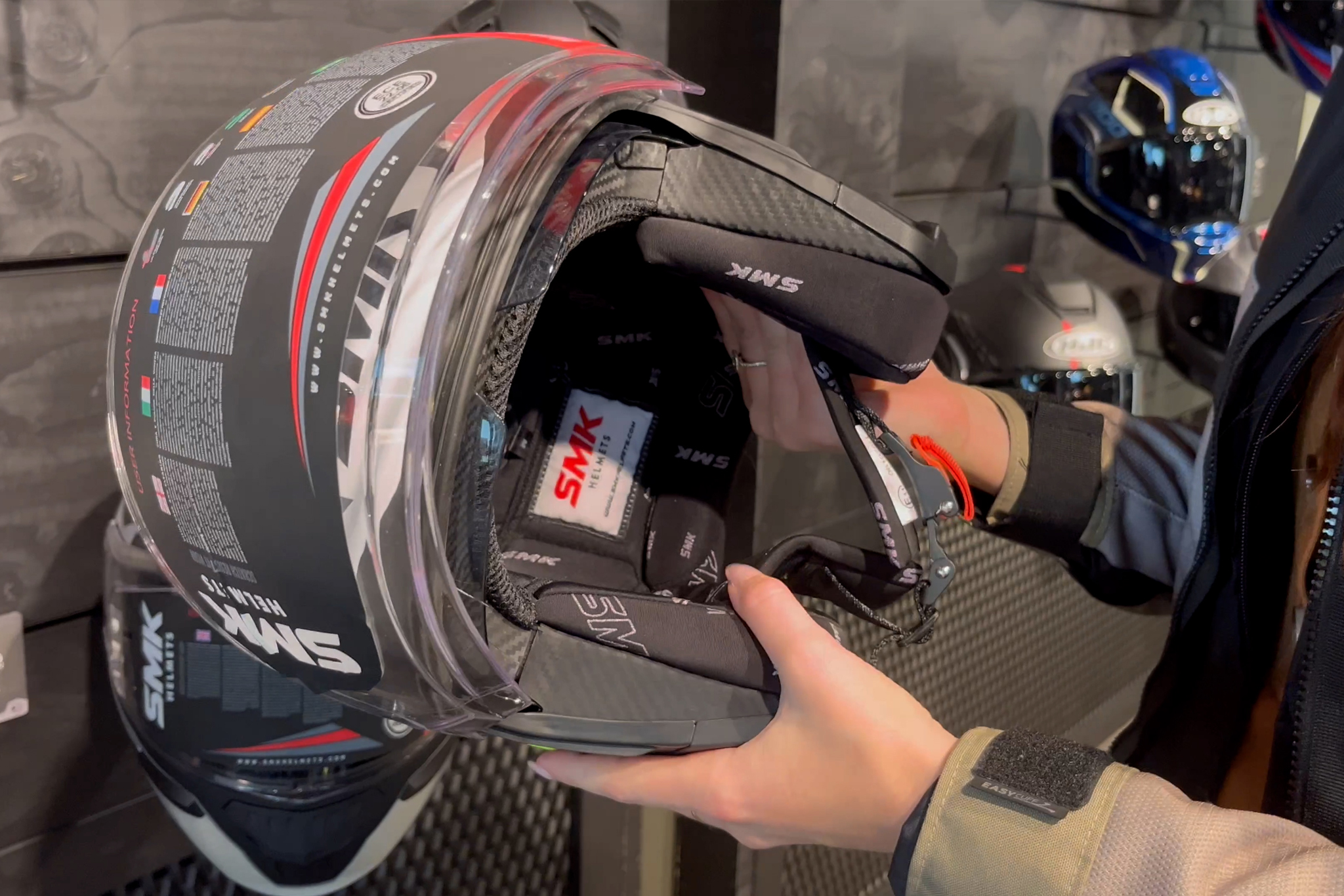 Close-up van een motorrijder die een SMK helm bekijkt